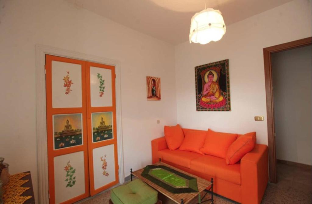 salon z pomarańczową kanapą i obrazem w obiekcie Da Marco Casa Vacanze Borgo Civita - ID 6678 CIN w mieście Trevi nel Lazio