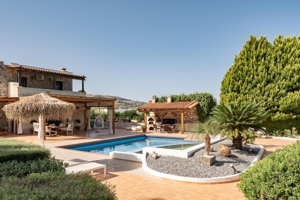 a villa with a swimming pool and a house at Agnes Villa, Unrivalled Living with Private Pool, By ThinkVilla in Pigi