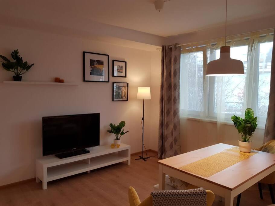 sala de estar con TV y mesa de comedor en Living City, apartament cu două dormitoare, en Sibiu