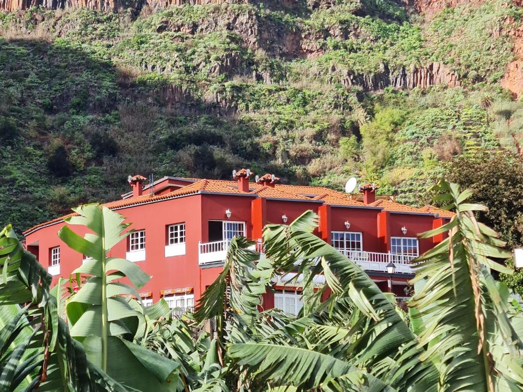 un edificio naranja frente a una montaña en Viviendas Vacacionales Escuela en Agulo