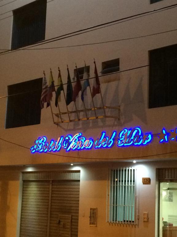 a sign on the side of a building with flags at Hotel Viña del Mar in Tacna