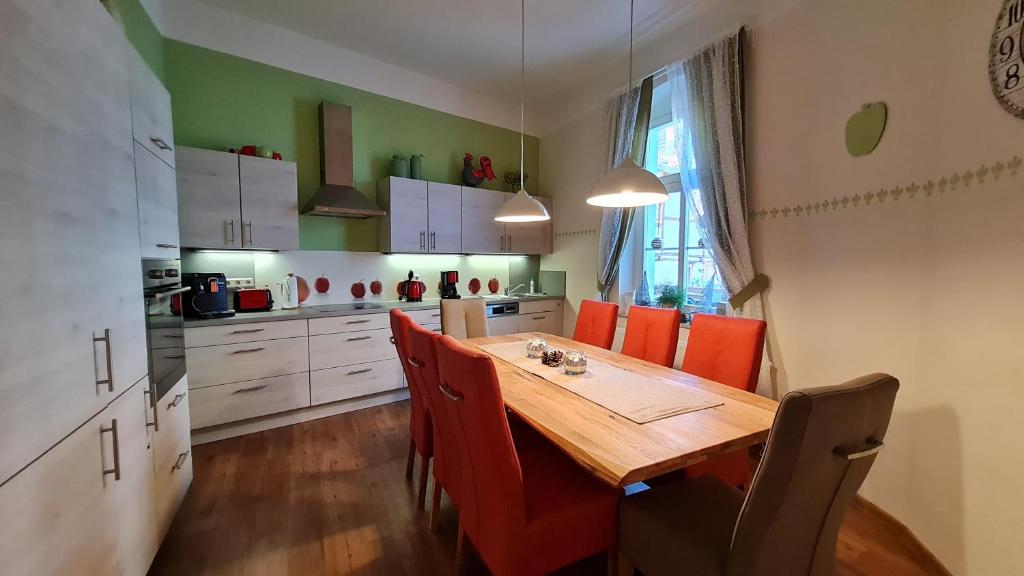 eine Küche mit einem Holztisch und roten Stühlen in der Unterkunft Ferienwohnung am Kaiserhof in Quedlinburg