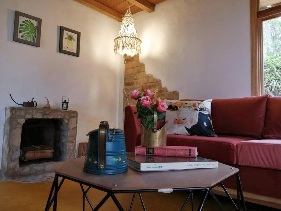 uma sala de estar com um sofá e uma mesa com flores em ALMA Glamping - San Francisco Cund - A 1h de Bogotá em San Francisco