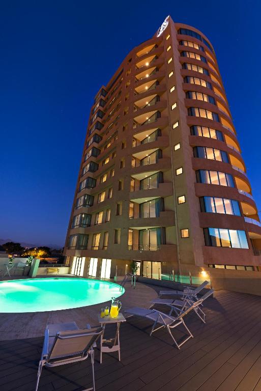 un edificio con sillas y una piscina frente a un edificio en Hotel Atacama Suites, en Copiapó