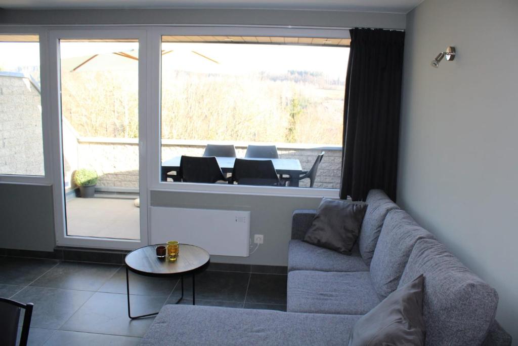 a living room with a couch and a table at TERRASSES DE MALMEDY Triplex 224 LE CERF BLANC in Malmedy