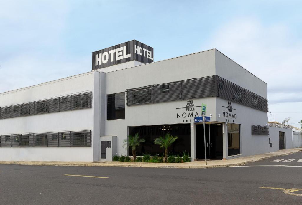 a large white building with a hotel at VILLA NOMAD HOTEL in Uberaba