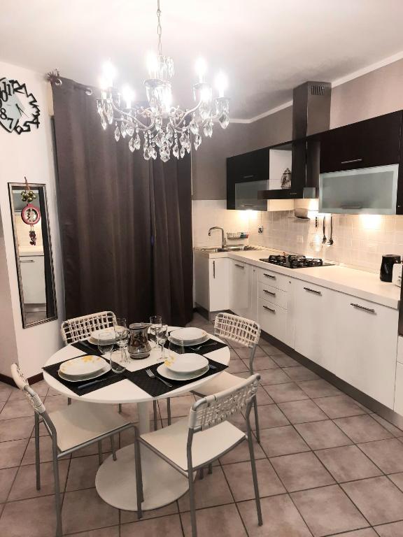 Hotel APPARTAMENTI REPUBBLICA FIERA district, a kitchen with a table and chairs and a chandelier at APPARTAMENTI REPUBBLICA FIERA district in Bologna