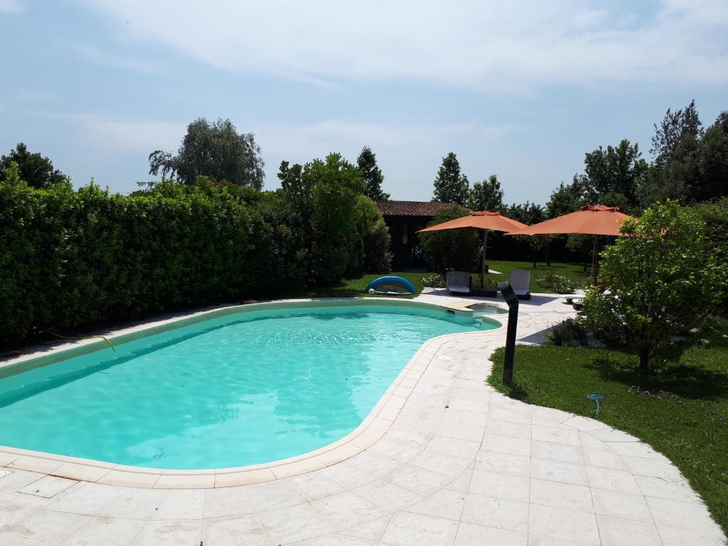 Conscio的住宿－Two Elegant Depandance，一个带遮阳伞的庭院内的游泳池