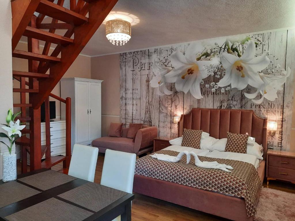 a living room with a bed and a staircase at Kék Lagúna Wellness Apartmanok in Egerszalók
