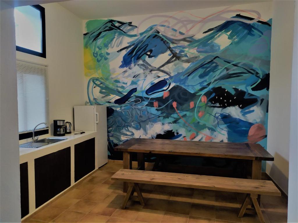 una cucina con tavolo e un dipinto sul muro di Casa Mocan ad Arrecife