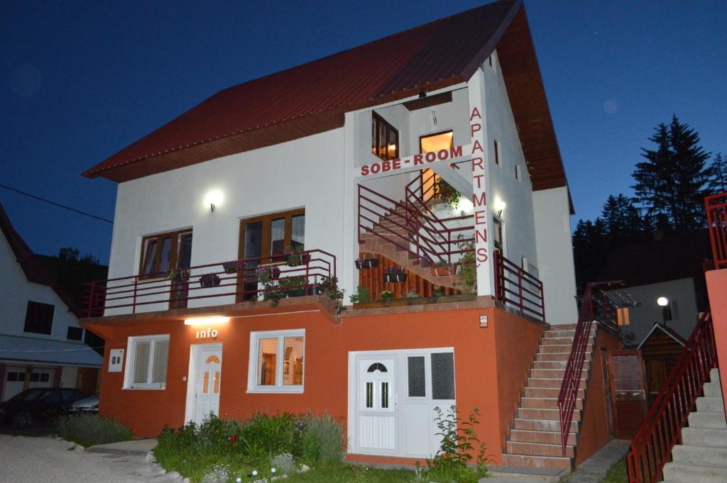 a small house with stairs on the side of it at Apartmani Božana Vojinović in Žabljak