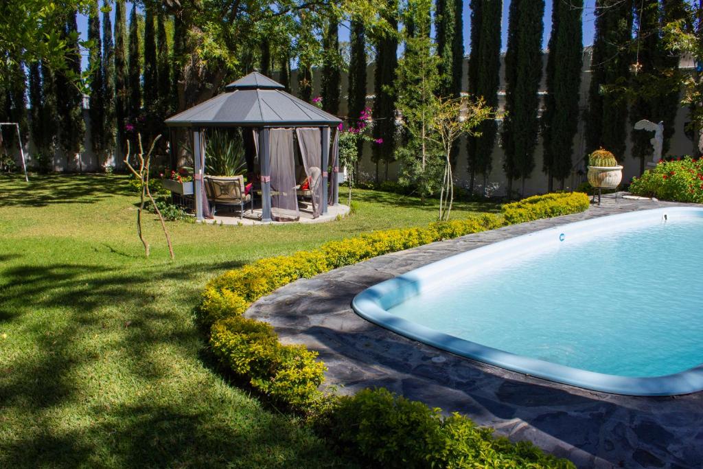 een zwembad in een tuin met een tuinhuisje bij Finca del Rocio in Parras de la Fuente