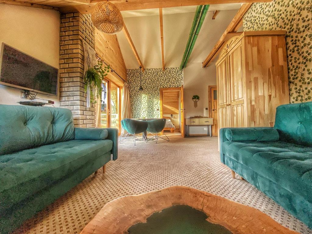 ein Wohnzimmer mit einem Sofa und einem Tisch in der Unterkunft Dziejba Leśna Apartamenty &Spa in Jaworki