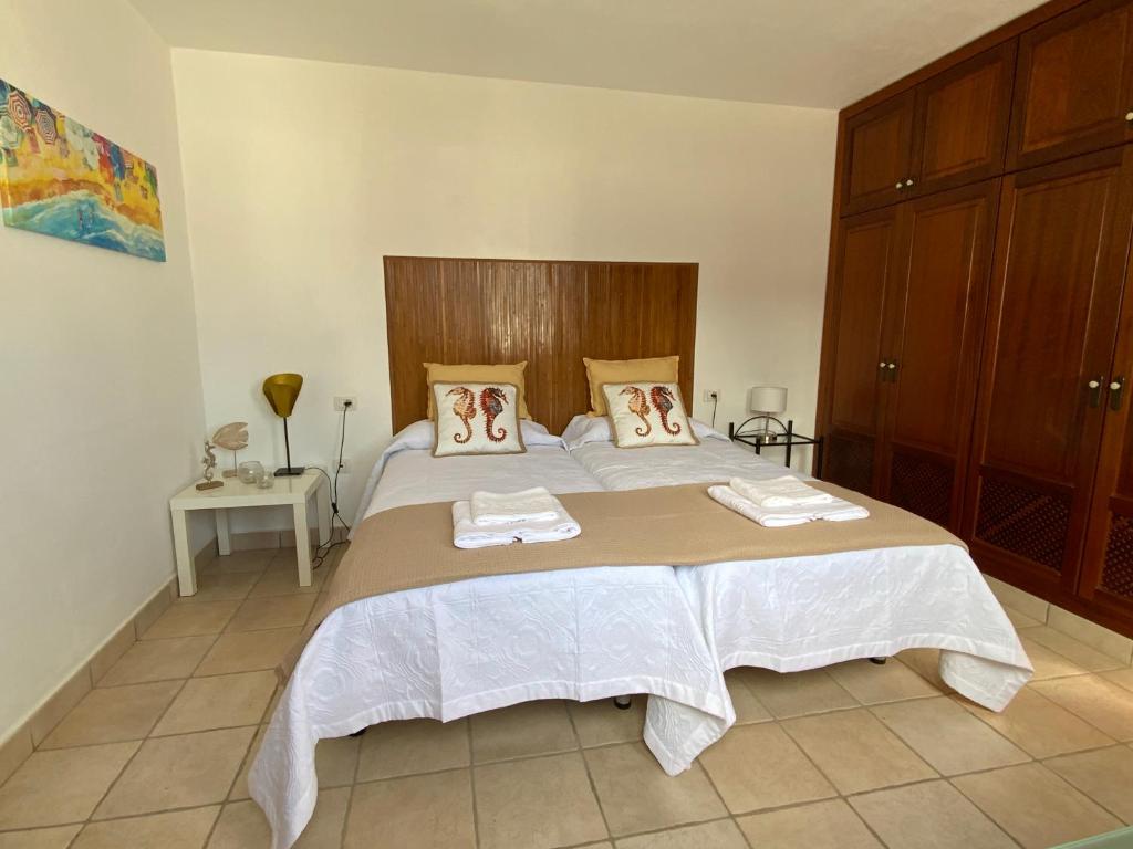 een slaapkamer met een groot bed en 2 handdoeken bij CALIMA Holiday House in Caleta de Sebo