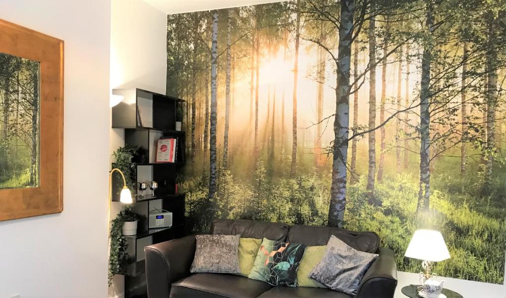 ein Wohnzimmer mit einem Sofa und einem Waldbild in der Unterkunft Central Wigan welcoming Townhouse sleeps up to 6 in Wigan