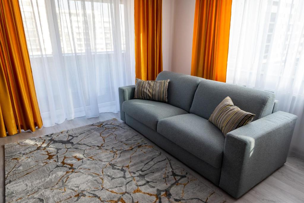 a living room with a couch and orange curtains at Apart B&V in Braşov