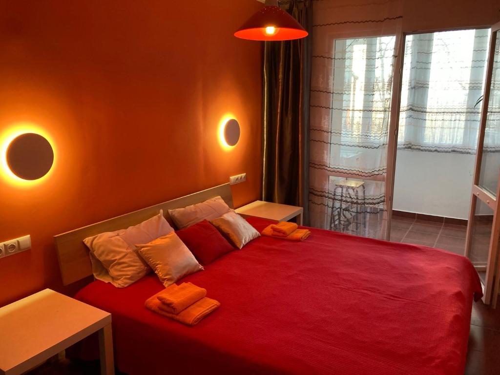 una camera con letto rosso e cuscini arancioni di Apartament Bazyla a Truskavec'