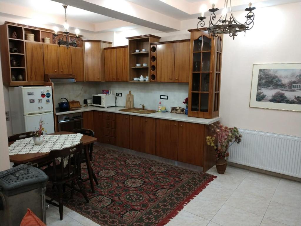 uma cozinha com armários de madeira e uma mesa em Vila Garden View em Korçë