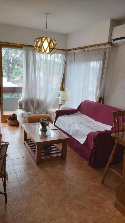 1 dormitorio con cama y mesa de centro en el Departamento Malevo en Villa Gesell