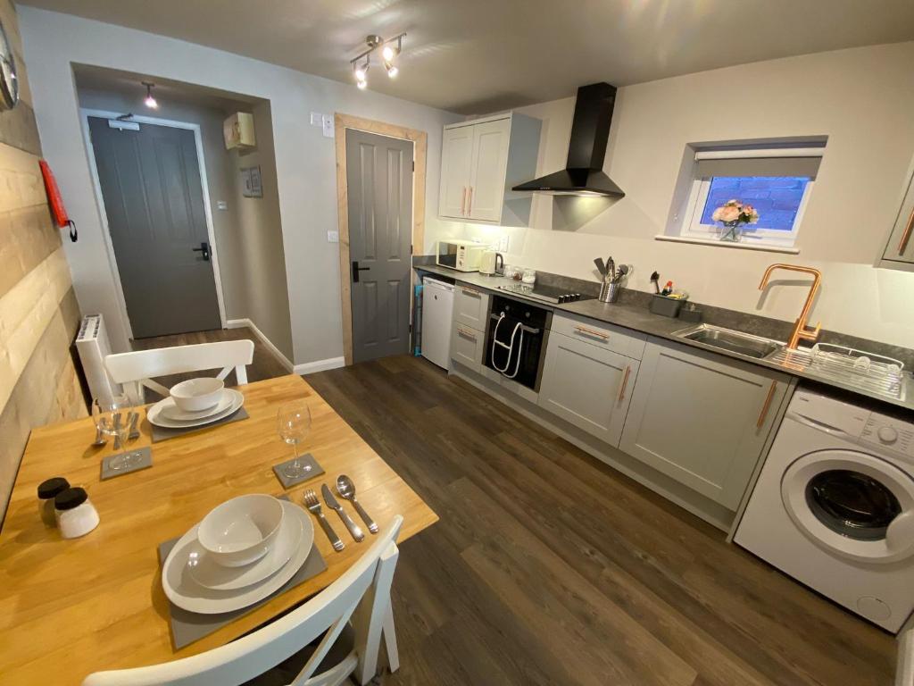 uma cozinha e sala de jantar com uma mesa e um lavatório em Studio at Bastion Mews em Hereford