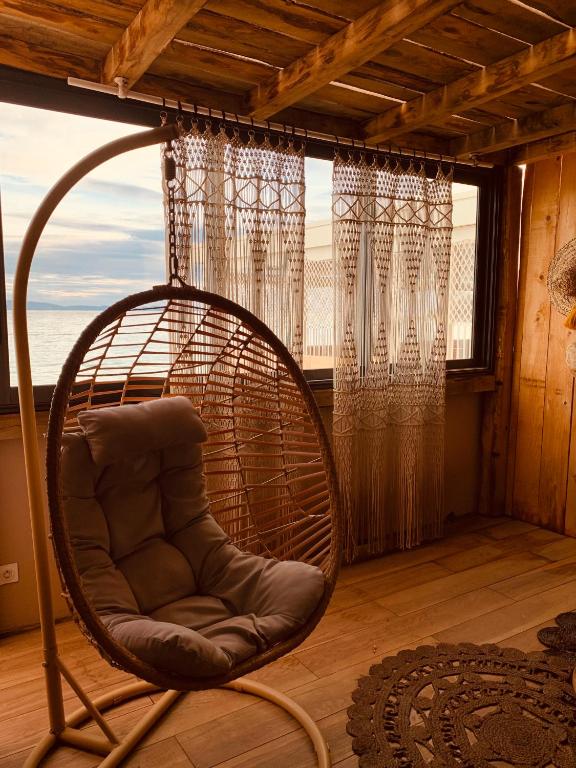 a rattan chair sitting in a room with a window at Palm Beach in Ajaccio