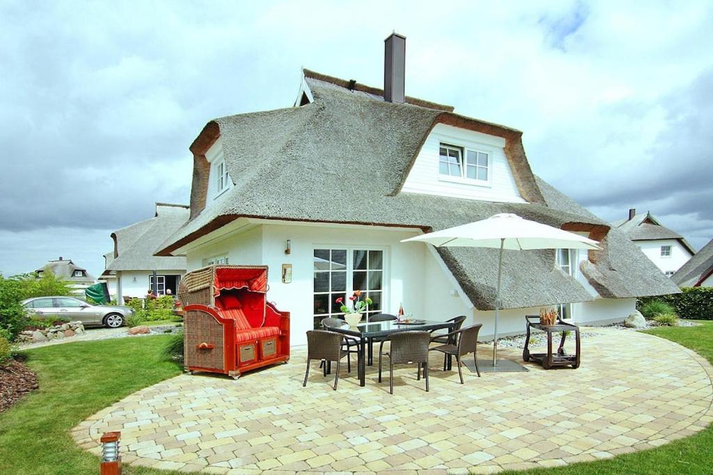 una casa con una mesa y sillas frente a ella en Ferienhaus Weiße Düne in Zinnowitz, en Zinnowitz