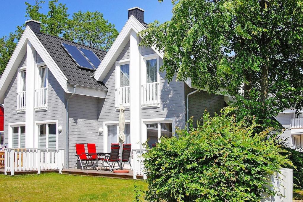 a house with red chairs on the front porch at Semi-detached house Rügentraum, Glowe in Glowe