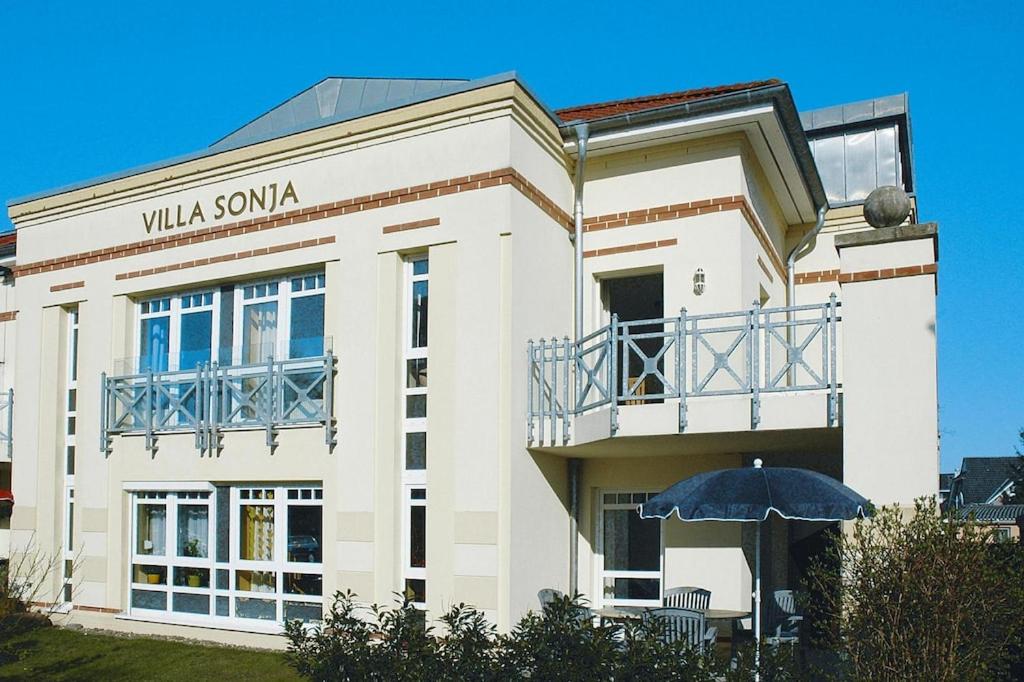 a white building with an umbrella in front of it at Apartment Villa Sonja, Zingst in Zingst