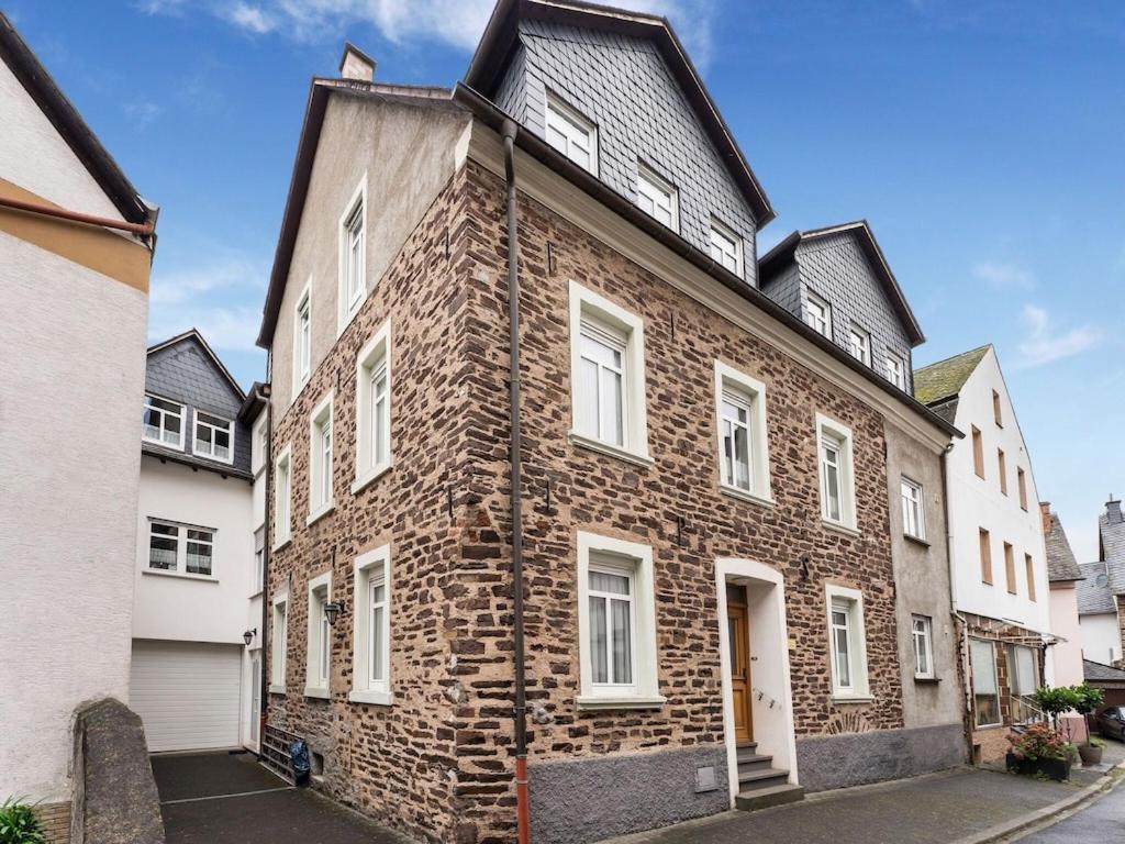 a brick building with white windows on a street at Comfortable Apartment in Ediger Eller Eifel in Sankt Aldegund