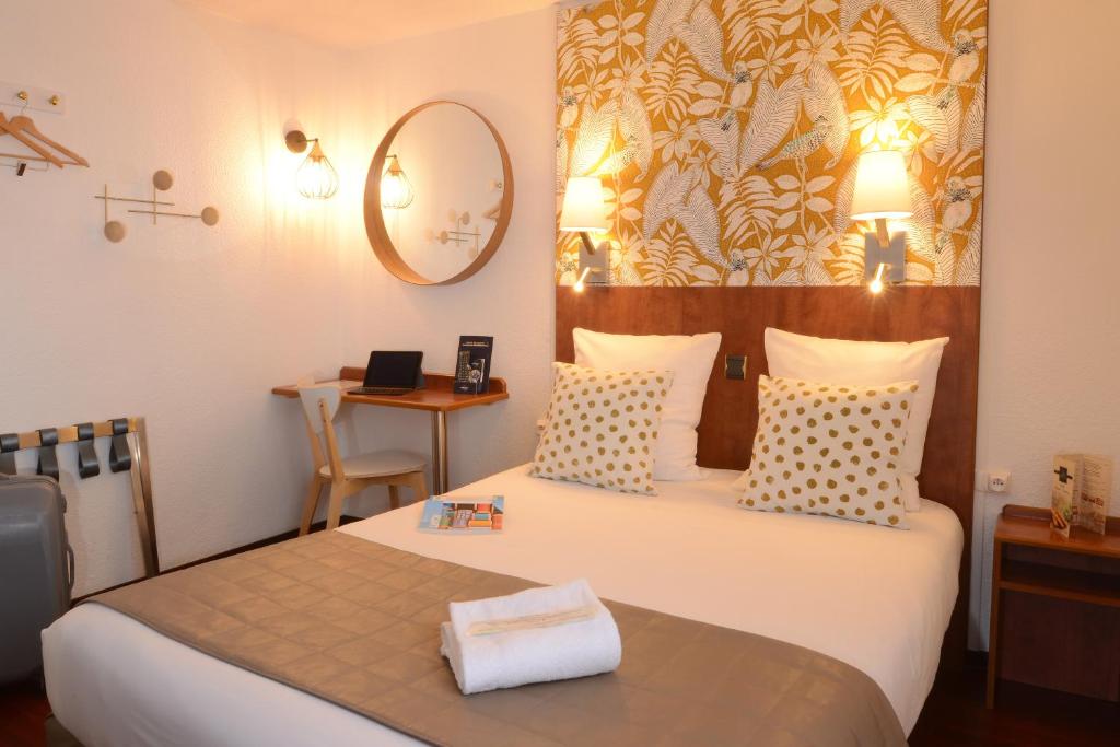 1 dormitorio con cama y mesa con espejo en Hotel Arc-En-Ciel Colmar Contact Hotel, en Colmar