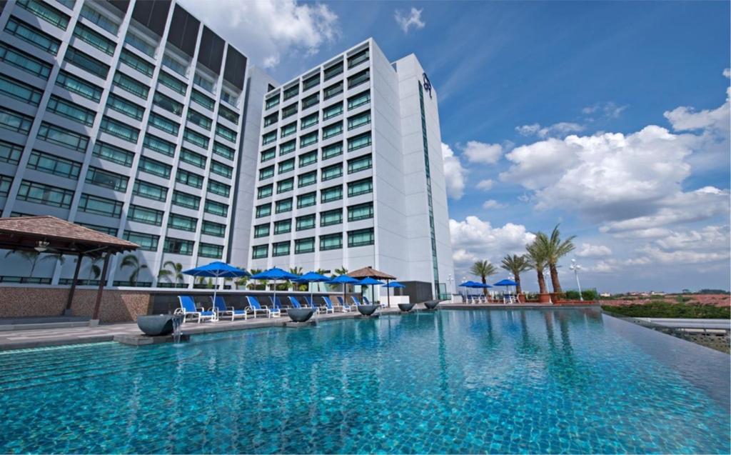 un hotel con piscina di fronte a un edificio di Royale Chulan Damansara a Petaling Jaya