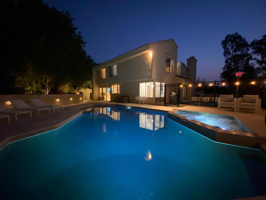 a swimming pool in front of a house at night at OCLuxeBnB Private Resort Living Minutes from Beach in Laguna Hills
