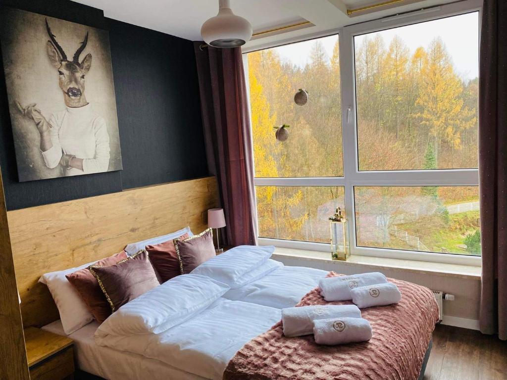 a bedroom with a bed and a large window at Apartament SPA 52 Resort Kozubnik blisko Szczyrk- 5D Apartamenty in Porąbka