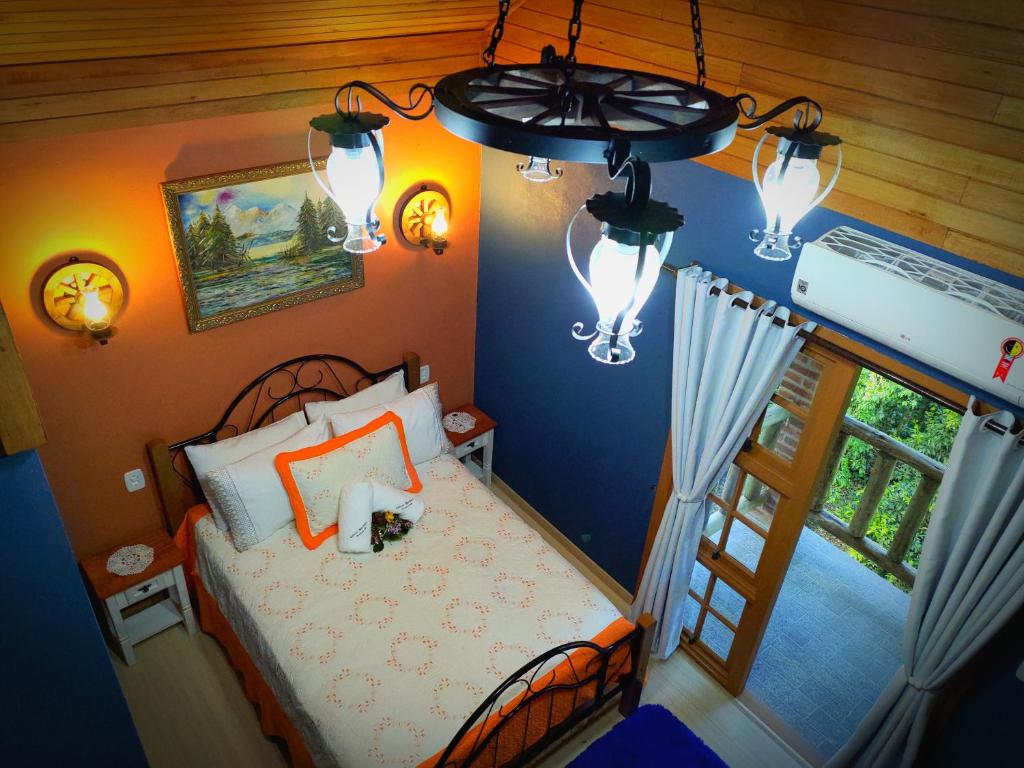 1 dormitorio con cama, ventana y luces en Cabana Drechsler Gramado, en Gramado