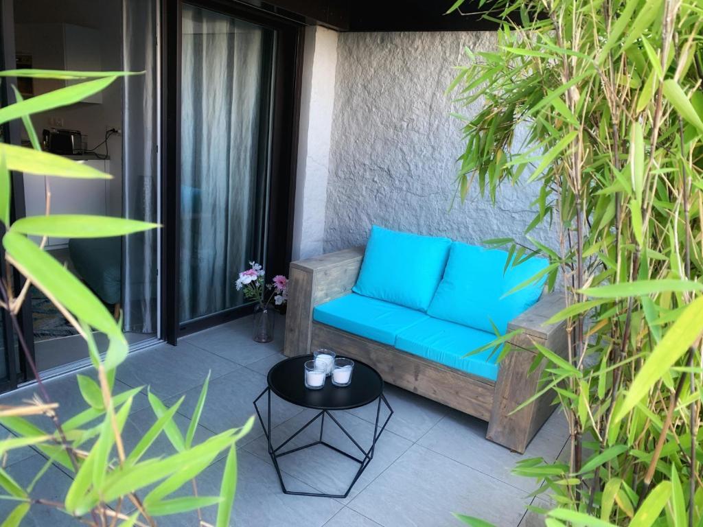 - un canapé bleu sur une terrasse ornée de plantes dans l'établissement La Légende, 2 pièces avec parking privé gratuit près du lac, à Annecy
