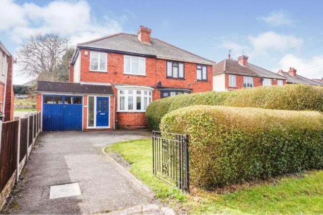 a large red brick house with a blue garage at L & J ESCAPES- 4 BEDROOMs SUITABLE FOR CONTRACTORS AND FAMILIES- LARGE PRIVATE PARKING-10 MINUTES TO M6 JUNCTION 9 in Coseley