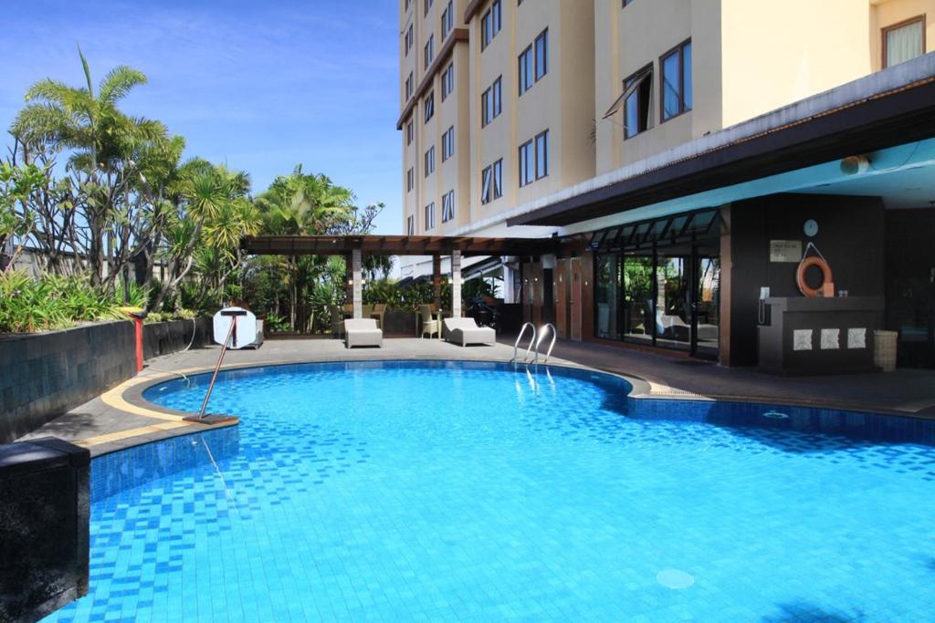 a swimming pool in front of a building at Daily Home Apartment in Bandung