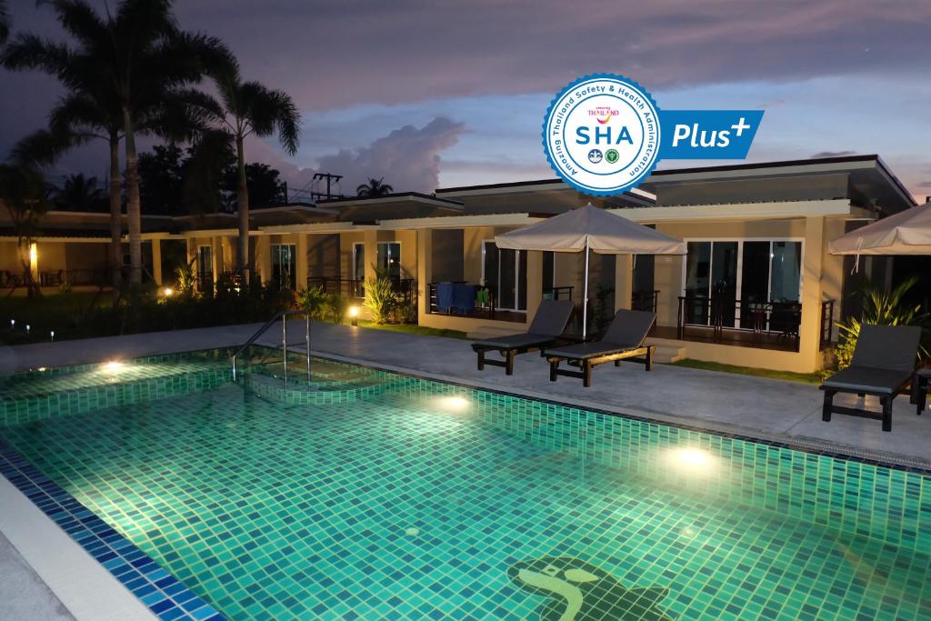 a swimming pool in front of a hotel at night at The Oasis Khaolak Resort - SHA Plus in Khao Lak