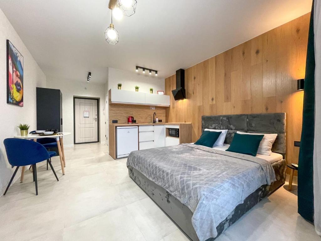 1 dormitorio con 1 cama grande y cocina en Апартаменты с видом на Лес и Реку, en Barnaul