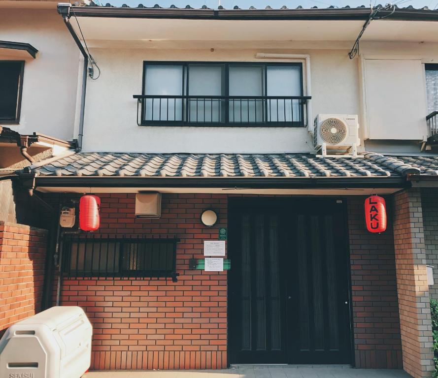 a house with a black door and a balcony at Kyoto Nijo Guest House HoshiIke villa in Kyoto