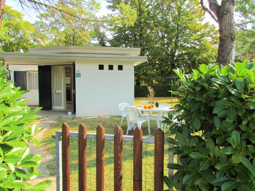 una recinzione di fronte a una piccola casa con tavolo di The perfect family retreat - Beahost a Bibione