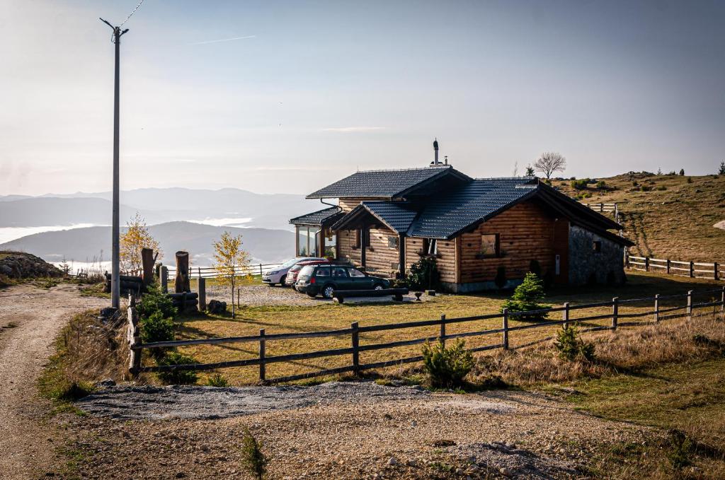 a house on top of a hill with a fence at Planinska kuća "Sedam Vlašića" in Vlasic