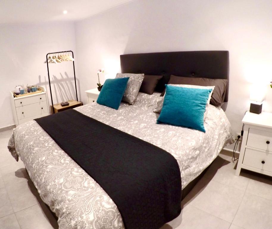 1 dormitorio con 1 cama grande con almohadas azules en KiCo, en Cómpeta