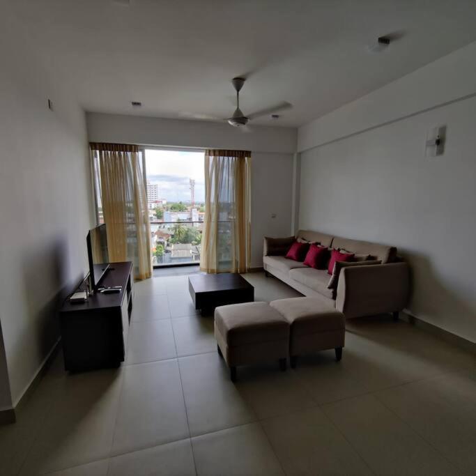 sala de estar con sofá y TV en Modern apartment in close proximity to the Beach en Colombo