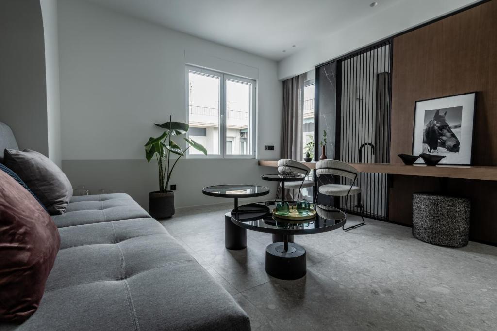 uma sala de estar com um sofá e uma mesa em Athinaion Recreation Suites em Atenas
