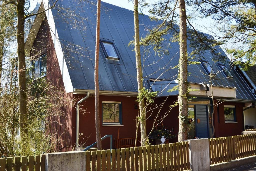 a house with a blue roof and a fence at Ferienwohnung BackHaus in Bad Bocklet