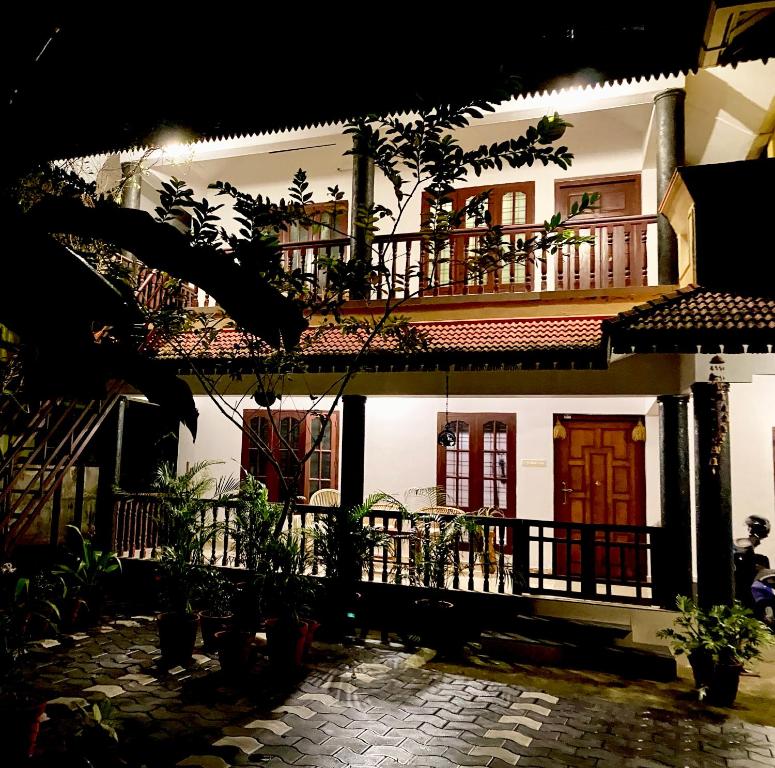 a large white house with a balcony at Tattwamasi Ayuryoga with Breakfast and Yoga in Varkala