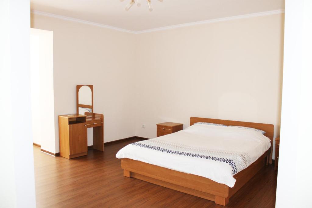 a bedroom with a bed and a night stand at Центр міста однокімнатна новобудова in Lutsk