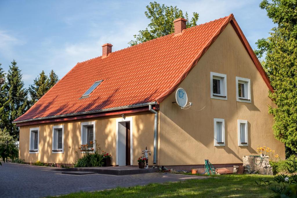 a large house with an orange roof at Domek na wzgórzu Blanki in Lidzbark Warmiński