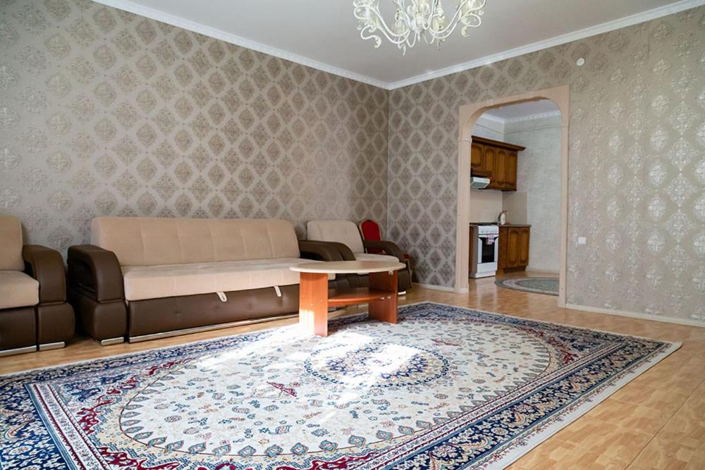 uma sala de estar com um sofá e um tapete em Gostinitsa "Sultan" em Aqtöbe